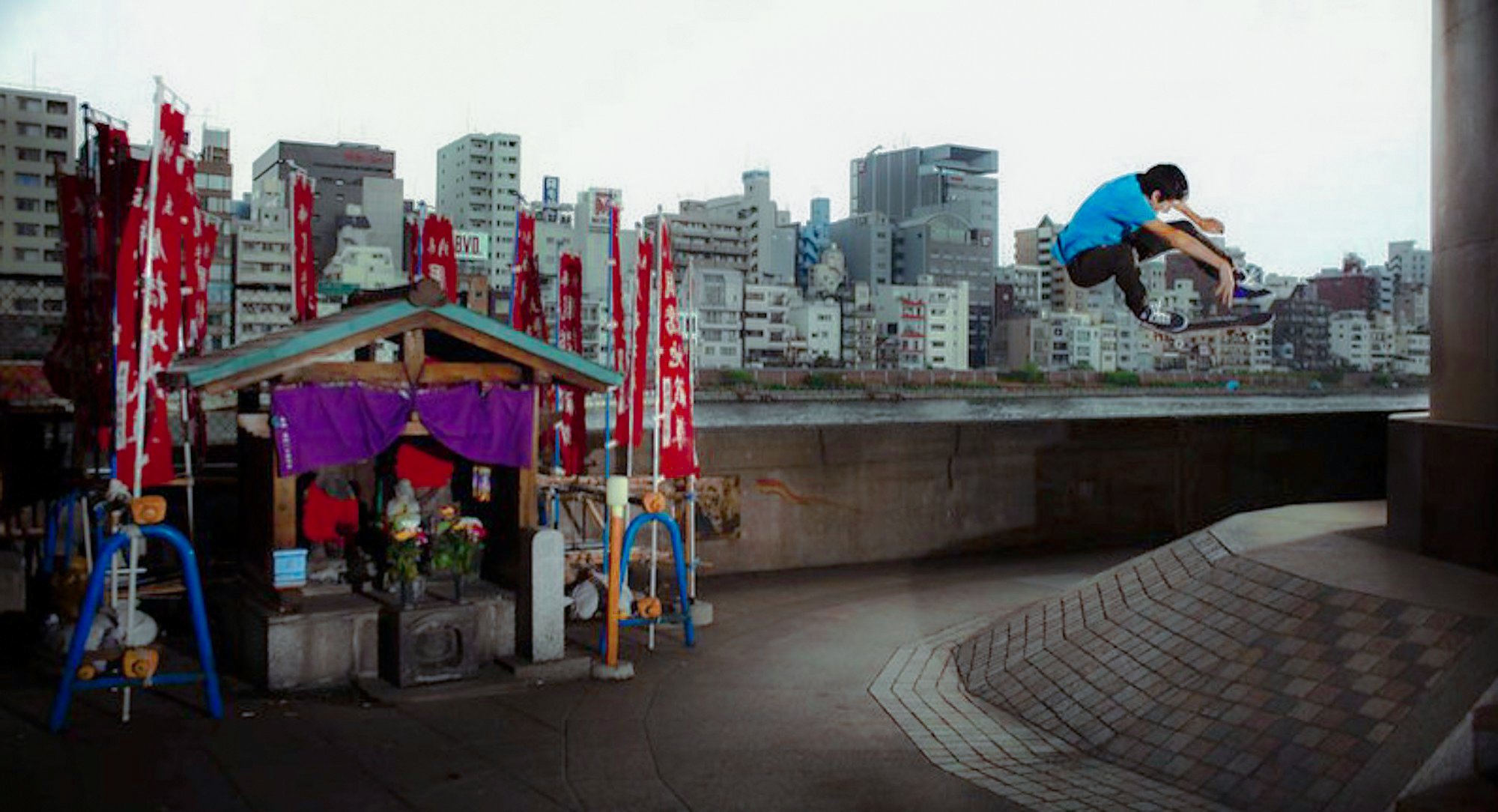 Skater saltando frente a un santuario japonés con el skyline de Tokio de fondo